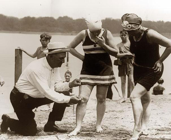 23.) Beach patrols measuring the length of women's bathing suits in the 1920s.