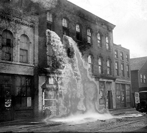 37.) Alcohol being poured out on the streets during Prohibition Detroit in 1929.