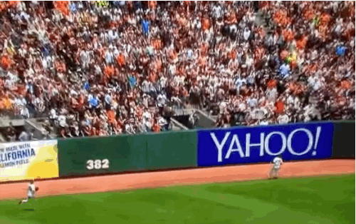 7. Just another day at the baseball field, child in arm.