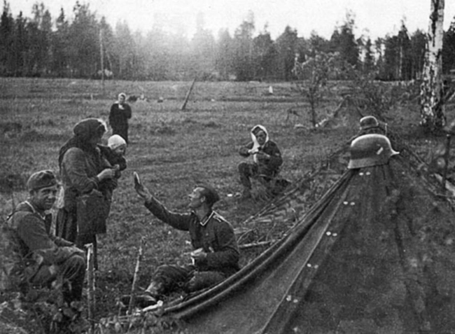 A German soldier sharing some of his food with a local Russian mother.
