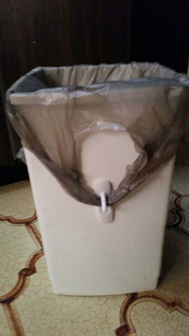 If you use grocery bags as trash bags in small garbage bins, here's how to keep the handles from flying around: