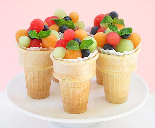 Serve balled fruit in ice cream cones. 