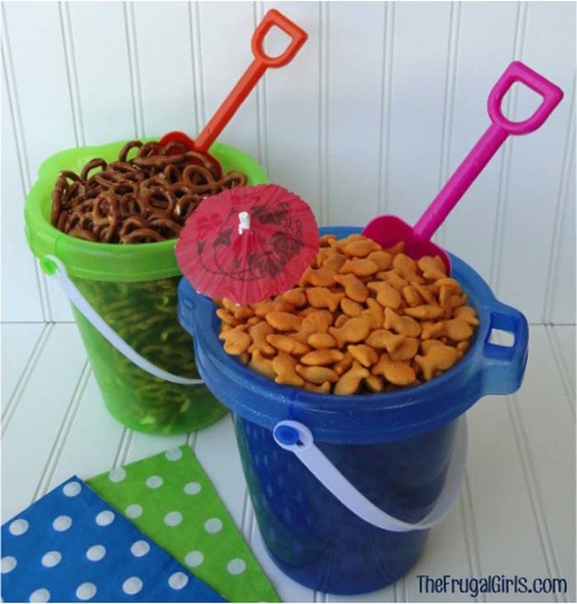 For a beach-themed party, keep snacks in buckets and use a toy shovel as a scoop.