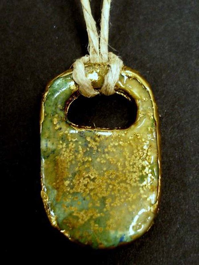 This pretty medallion is a soda tab filled with clear resin and gold flecks.