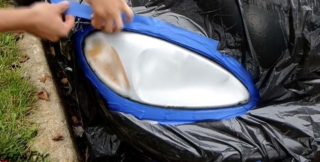 Tape the garbage bag around the headlight to prevent any dripping.