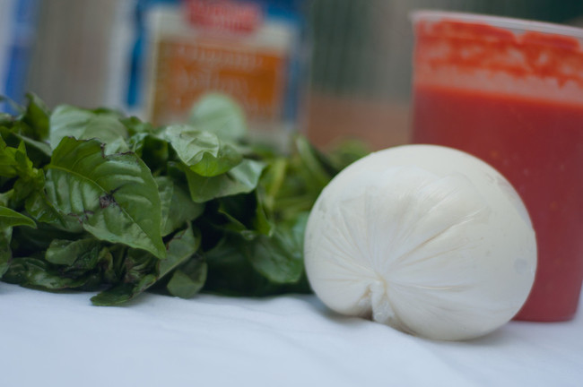 Before you get cooking, you need your pizza ingredients, including sauce, dough, cheese, and any veggies you want.