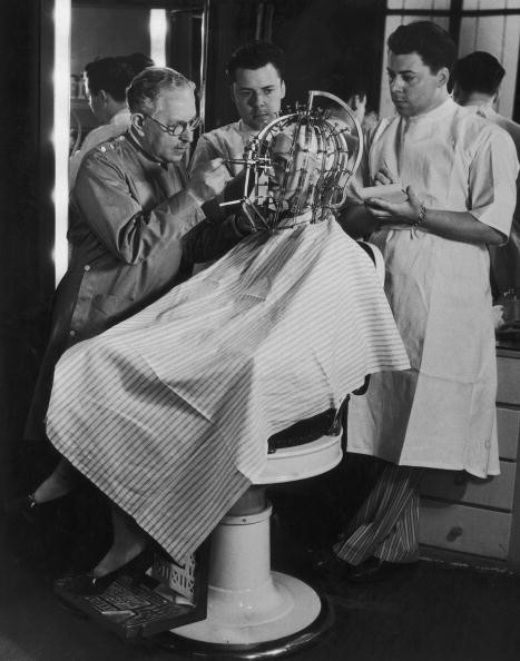Max Factor takes precise measurements of a young woman's head and face with his "Beauty Calibrator" (1932). Beauty has never been so horrifying.