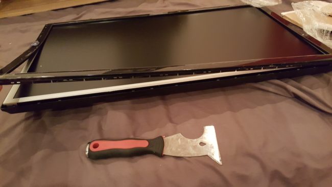 He then removed the bezel around the monitor.