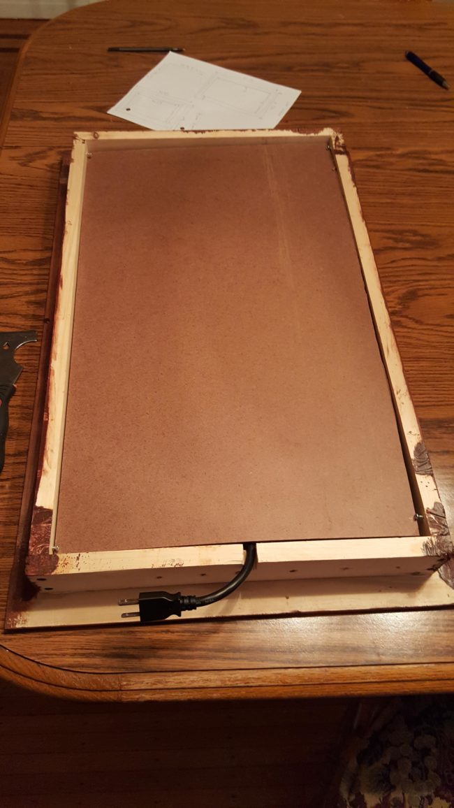 He used a breadboard to make the back of the mirror look nice. This addition also helped stabilize the wires.