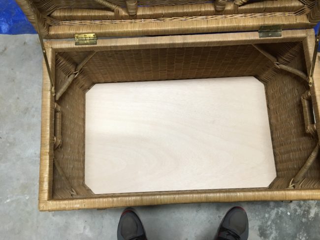 First, he cut the plywood to fit into the base of the chest.