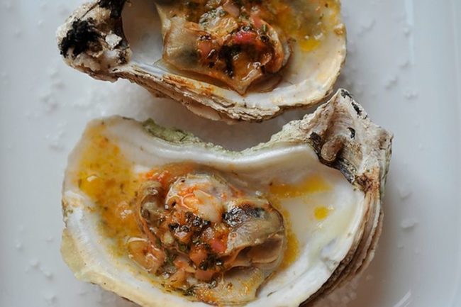 These grilled (or broiled) oysters with sriracha lime butter pair nicely with a glass of bubbly champagne.