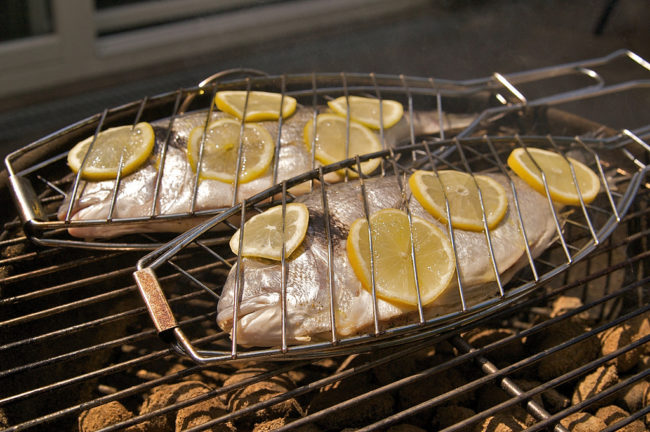 Grill fish with lemon for flavor and to keep it from sticking to the grates.