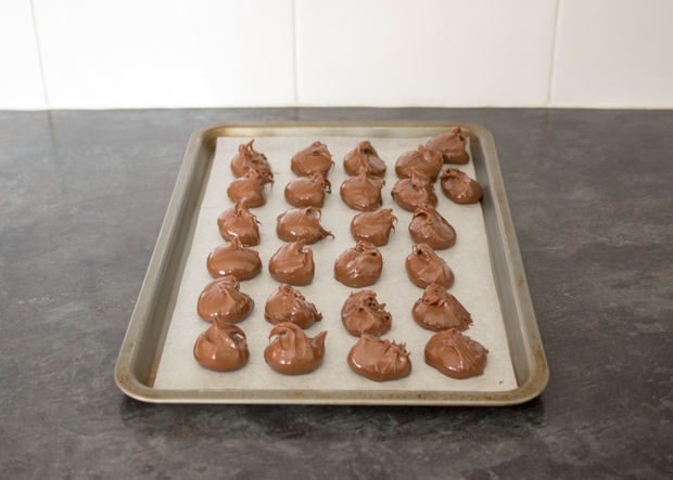 First, scoop out a few tablespoons of nutella onto wax paper. Then, put them in the freezer until they're completely solid.