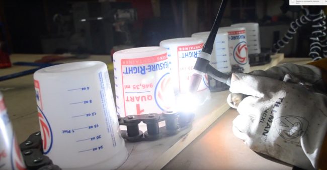 After tacking the links together, he removed the buckets and began welding the links so the chain would hold its shape.