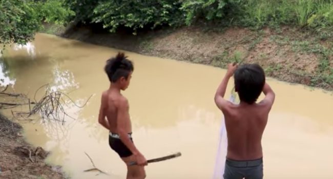 These two boys live in Cambodia, where they decided to go fishing in the muddy water one day.