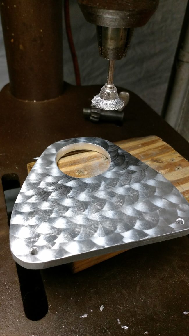 Using a wire cup brush, he gave his metal plate a textured appearance.