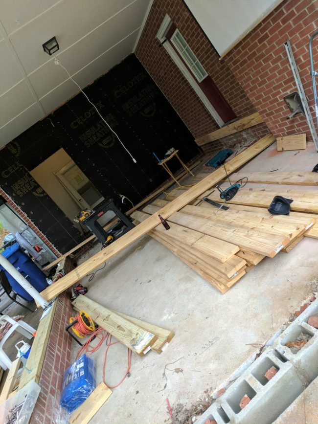 After removing the rear wall siding, our builder and a close friend began installing ledger boards and sill plates.