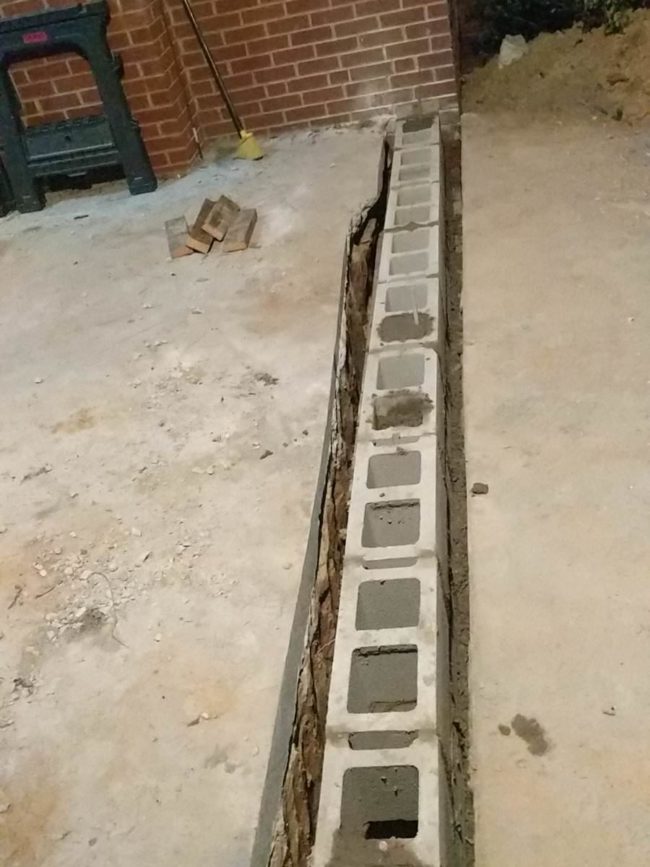 Once that was finished, he filled in the hole with cement and cinder blocks which he used as wall anchors.