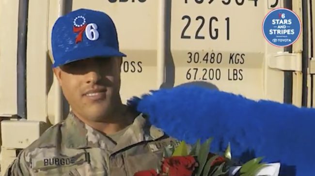In the middle of his shoutout, the team's mascot, Franklin the Dog, reached into the frame and whisked the serviceman away.