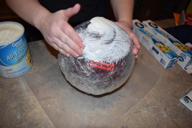 Slippery shortening was applied to the ball and layers upon layers of saran wrap, then shortening, then saran wrap were applied.