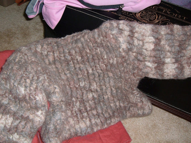 Reverse sweater shrinkage by soaking it in a mixture of warm water and two tablespoons of baby shampoo. Rinse with cool water, press out the excess, then roll it up into a towel to dry it out. After that, pull the sweater and pin it out on a stiff surface, stretching it every few hours until it's back to it's original size.