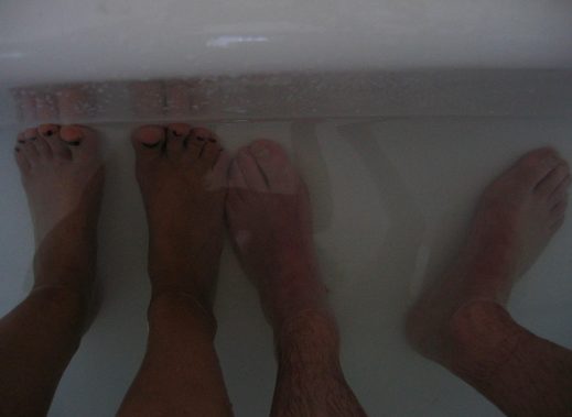 Start by placing your feet in a large bowl or tub of hat water mixed with one teaspoon of Epsom salts, which you can find at any drugstore or big box store. Leave your feet in there for 20 minutes a day until the infection is mostly cleared and the skin around the nail is supple.