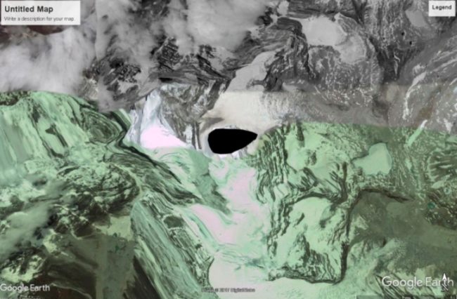 Someone dig through Stephan Hawking's work and figure out this black hole situation! Kangtega is a major mountain peak of the Himalayas in Nepal with a summit of 6,782 meters. What that black spot really is is the peak of the mountain. No one knows why the peak shows up like this on satellite images.